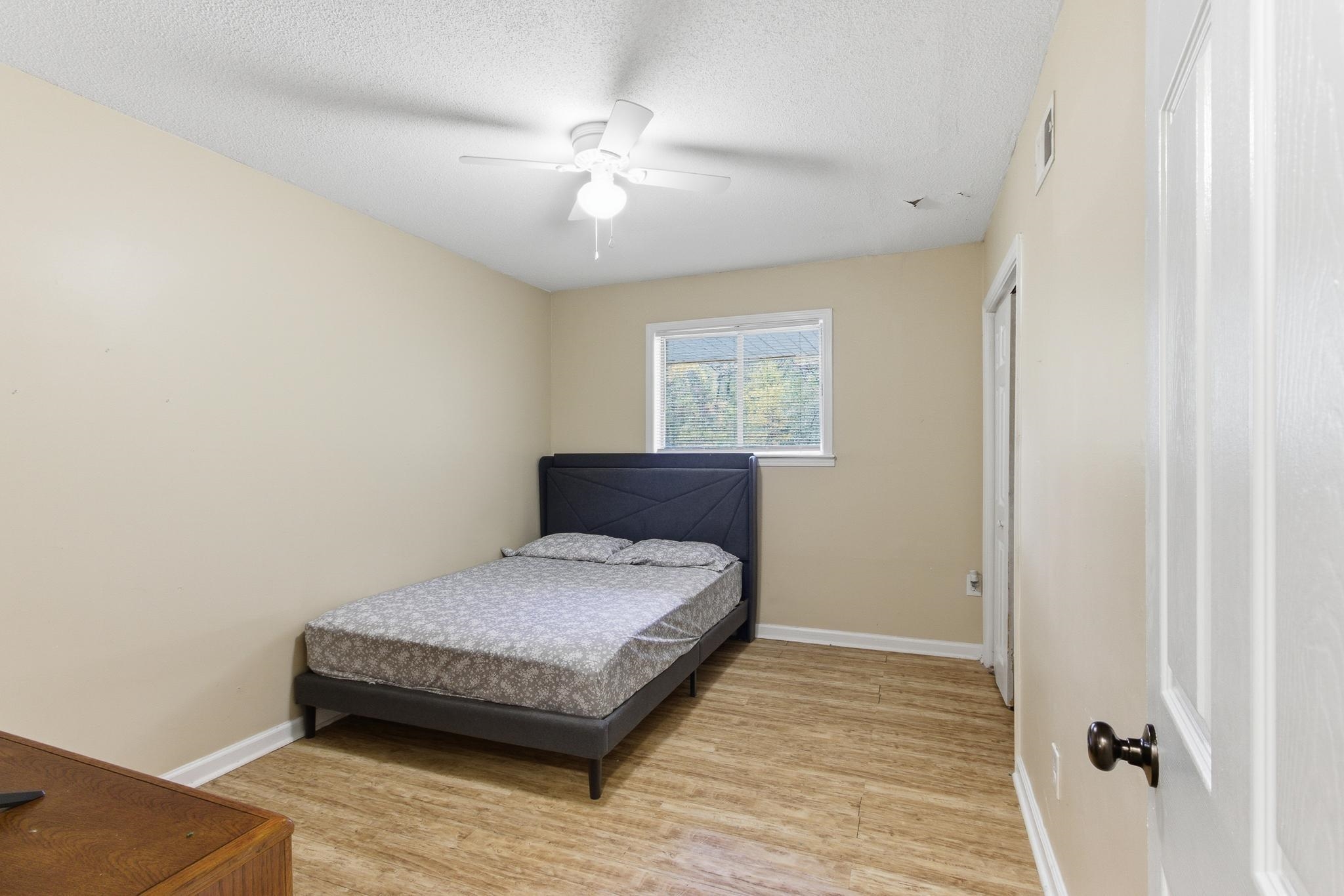 5002 Benjestown Road Memphis, TN 38127 - Photo 23 of 29 Bedroom featuring light wood-style floors, a ceiling fan, and a textured ceiling