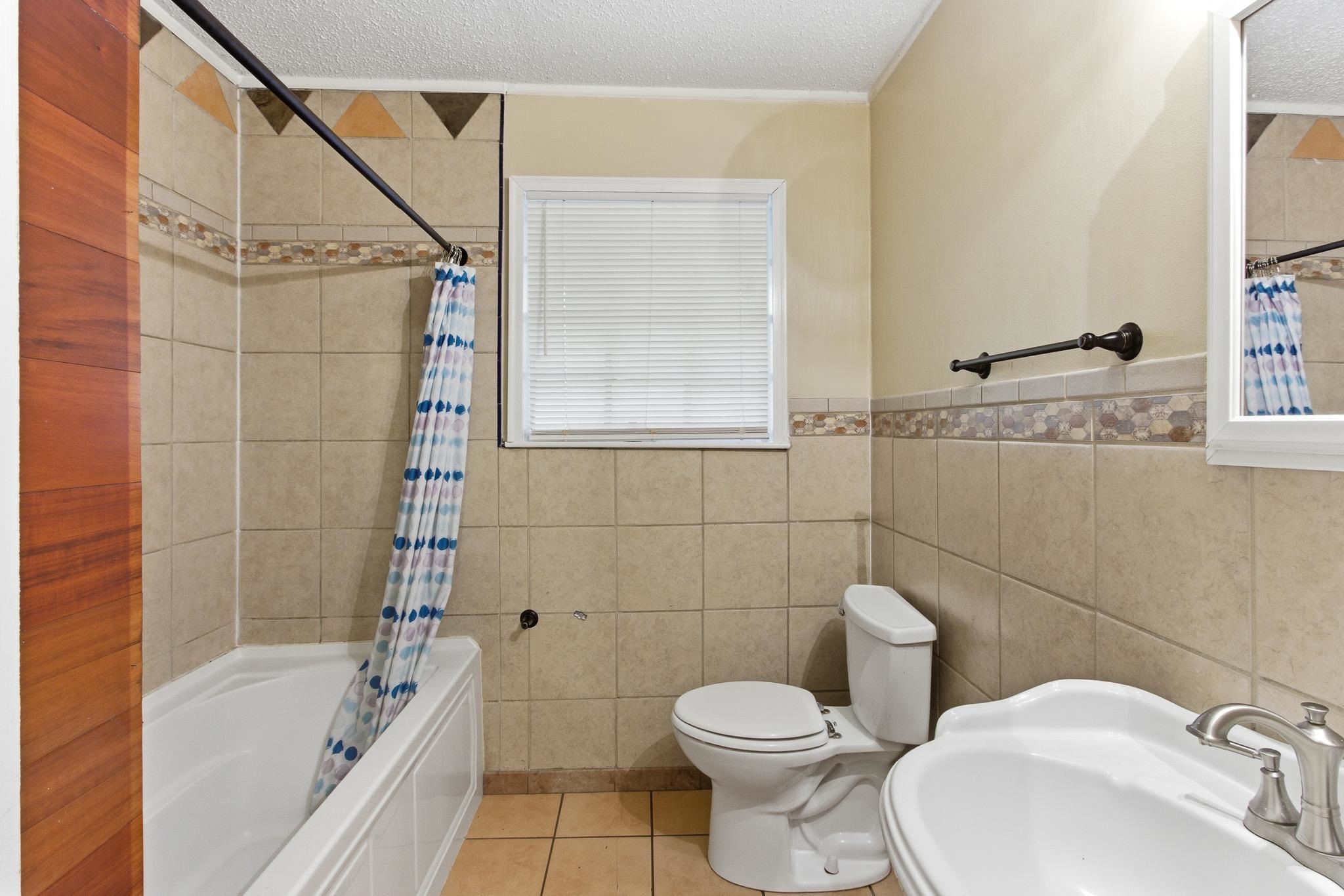 5002 Benjestown Road Memphis, TN 38127 - Photo 24 of 29 Full bathroom with light tile patterned floors, a textured ceiling, shower / tub combo, tile walls, and plenty of natural light
