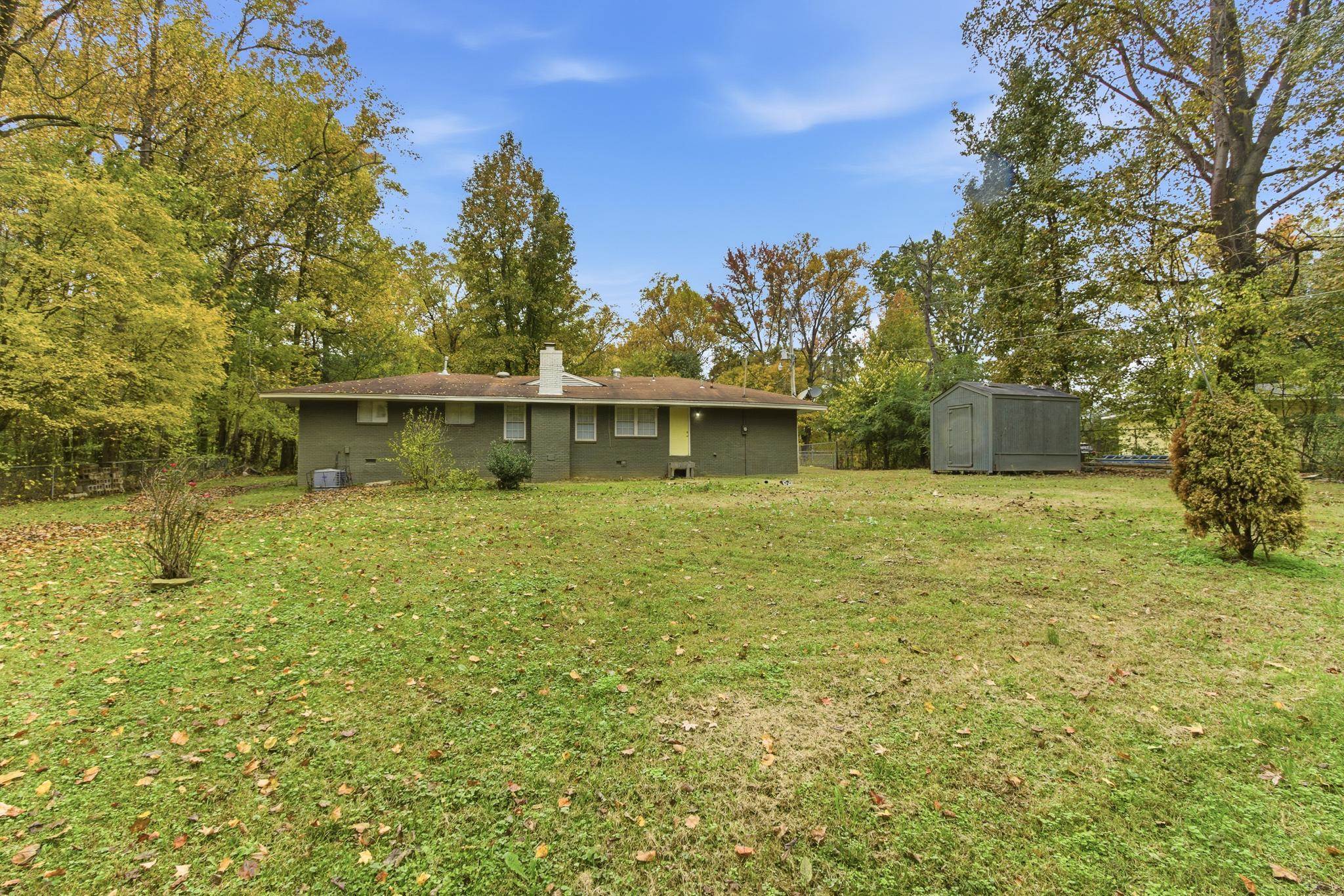 5002 Benjestown Road Memphis, TN 38127 - Photo 27 of 29 Rear view of property featuring a chimney, a storage unit, and brick siding