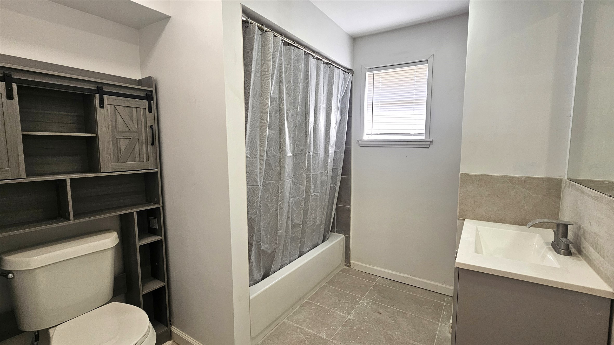 1202 Dyer Avenue, Unit A Rosenberg, TX 77471 - Photo 6 of 14 a bathroom with a toilet a sink and a window