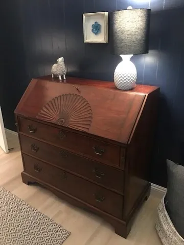 a bedroom with a bed and a lamp on dresser