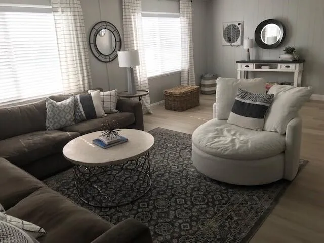 a living room with furniture a clock on wall and a window