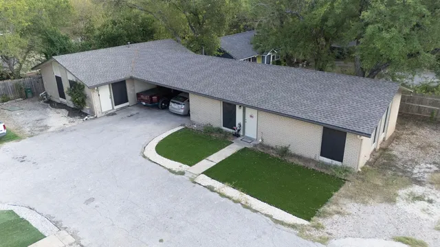 a aerial view of a house with a yard and large tree