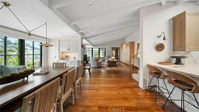a living room with furniture large window and wooden floor