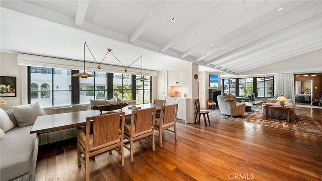a view of a dining room with furniture large windows and wooden floor