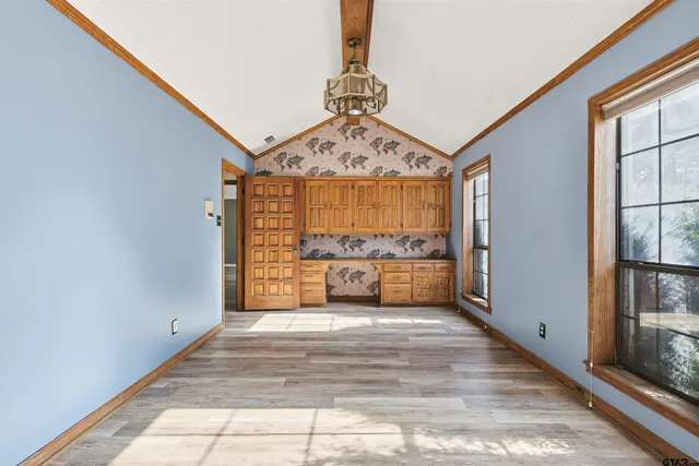 a view of a hallway with wooden floor and a bathroom