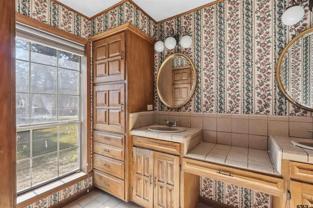 a view of a house next to a big yard and large trees