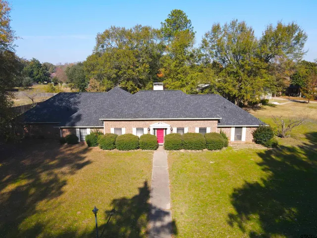 a front view of a house with a yard and trees