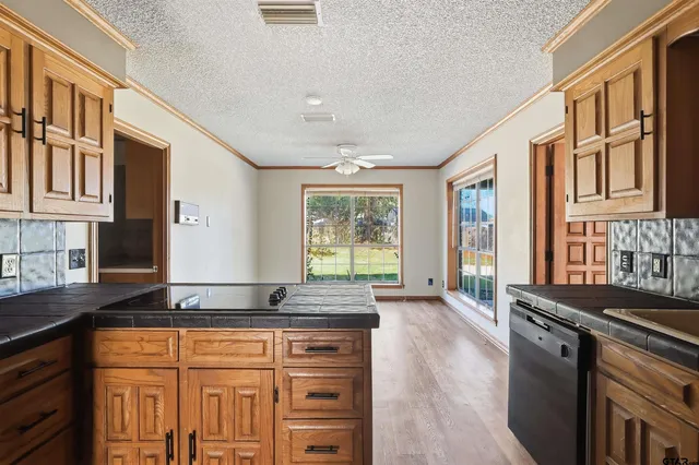 a kitchen with granite countertop a refrigerator and white cabinets