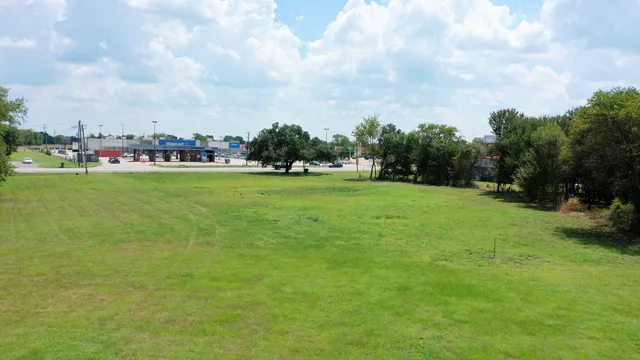 a view of a green field with wooden fence