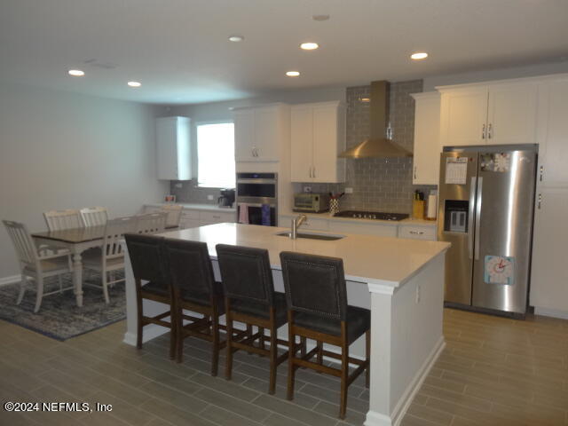 69 Trewin Circle St. Augustine, FL 32092 - Photo 6 of 36 a kitchen with stainless steel appliances granite countertop a table chairs sink refrigerator and microwave
