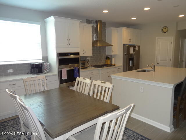 69 Trewin Circle St. Augustine, FL 32092 - Photo 7 of 36 a kitchen with stainless steel appliances granite countertop a table chairs and a refrigerator