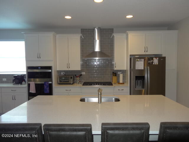 69 Trewin Circle St. Augustine, FL 32092 - Photo 8 of 36 a large white kitchen with kitchen island a stove a refrigerator a sink and white cabinets