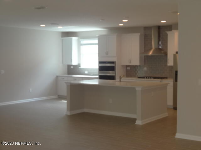 69 Trewin Circle St. Augustine, FL 32092 - Photo 9 of 36 a kitchen with kitchen island granite countertop a sink and a stove top oven