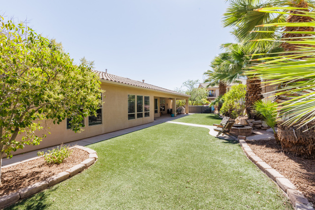 1257 West 2320 South St. George, UT 84770 - Photo 36 of 55 Expansive backyard featuring artificial turf, a covered patio, and mature palm trees
