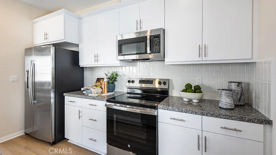 1700 Phantom Lane Rialto, CA 92376 - Photo 3 of 23 a kitchen with granite countertop white cabinets stainless steel appliances and sink