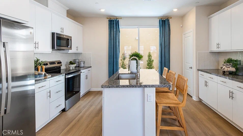 1700 Phantom Lane Rialto, CA 92376 - Photo 4 of 23 a kitchen with stainless steel appliances granite countertop a stove a sink and a refrigerator