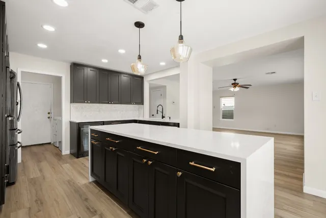 a kitchen with kitchen island a sink stainless steel appliances and cabinets