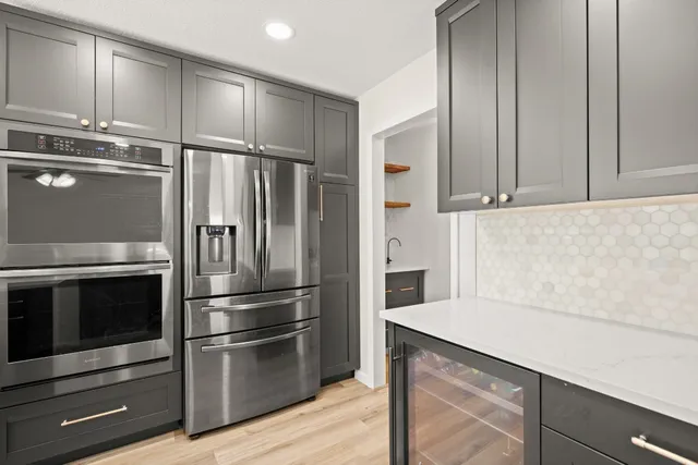 a kitchen with granite countertop a refrigerator and a stove top oven