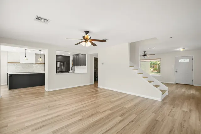 a view of a living room a kitchen and a wooden floor