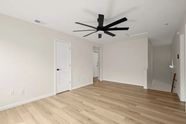 a view of empty room with wooden floor