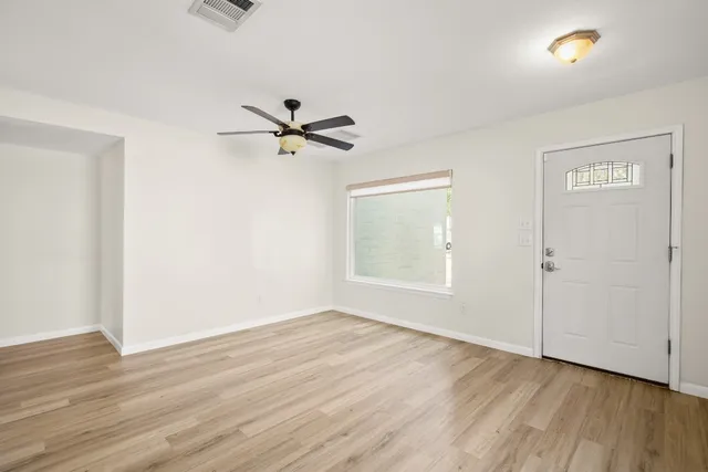 wooden floor in an empty room with a window