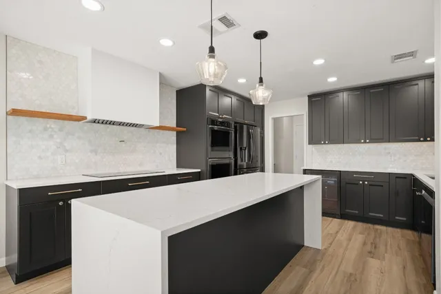 a kitchen with a sink a counter top space stainless steel appliances and cabinets