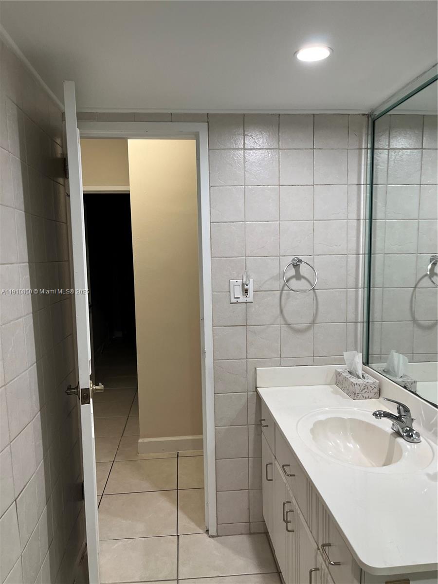 5161 Collins Avenue, Unit 214 Miami Beach, FL 33140 - Photo 11 of 13 a bathroom with a double vanity sink and mirror