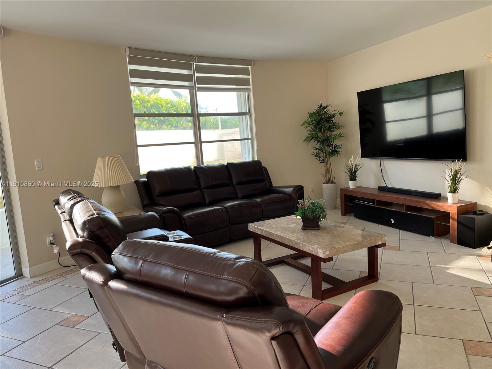 5161 Collins Avenue, Unit 214 Miami Beach, FL 33140 - Photo 4 of 13 a living room with furniture and a flat screen tv
