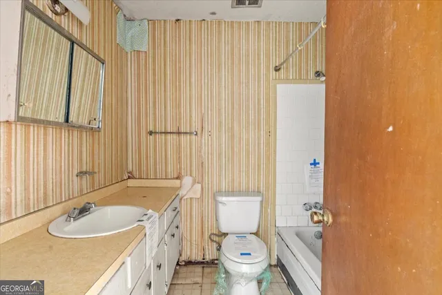 a bathroom with a sink a toilet and shower curtain