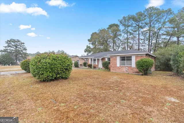 a front view of a house with a yard and trees