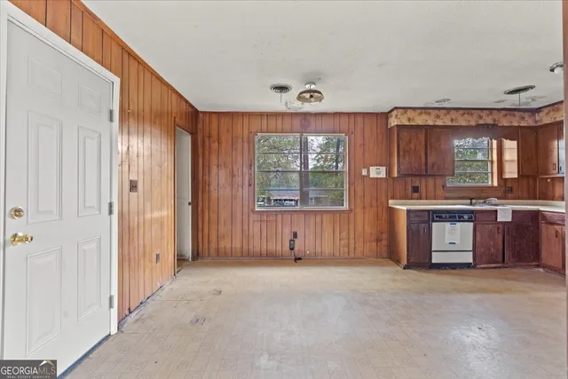 an empty room with a kitchen and windows