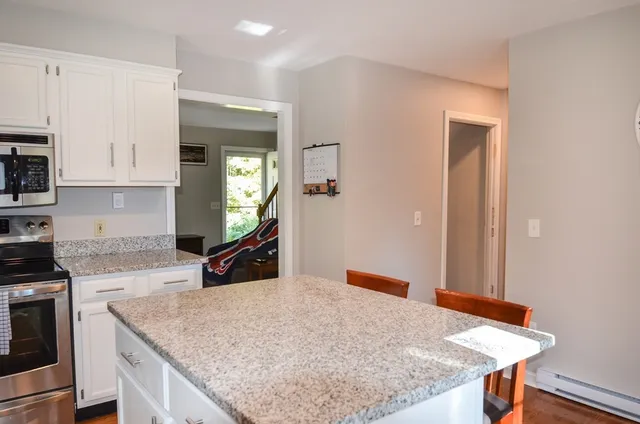 a kitchen with a stove and a wooden floor