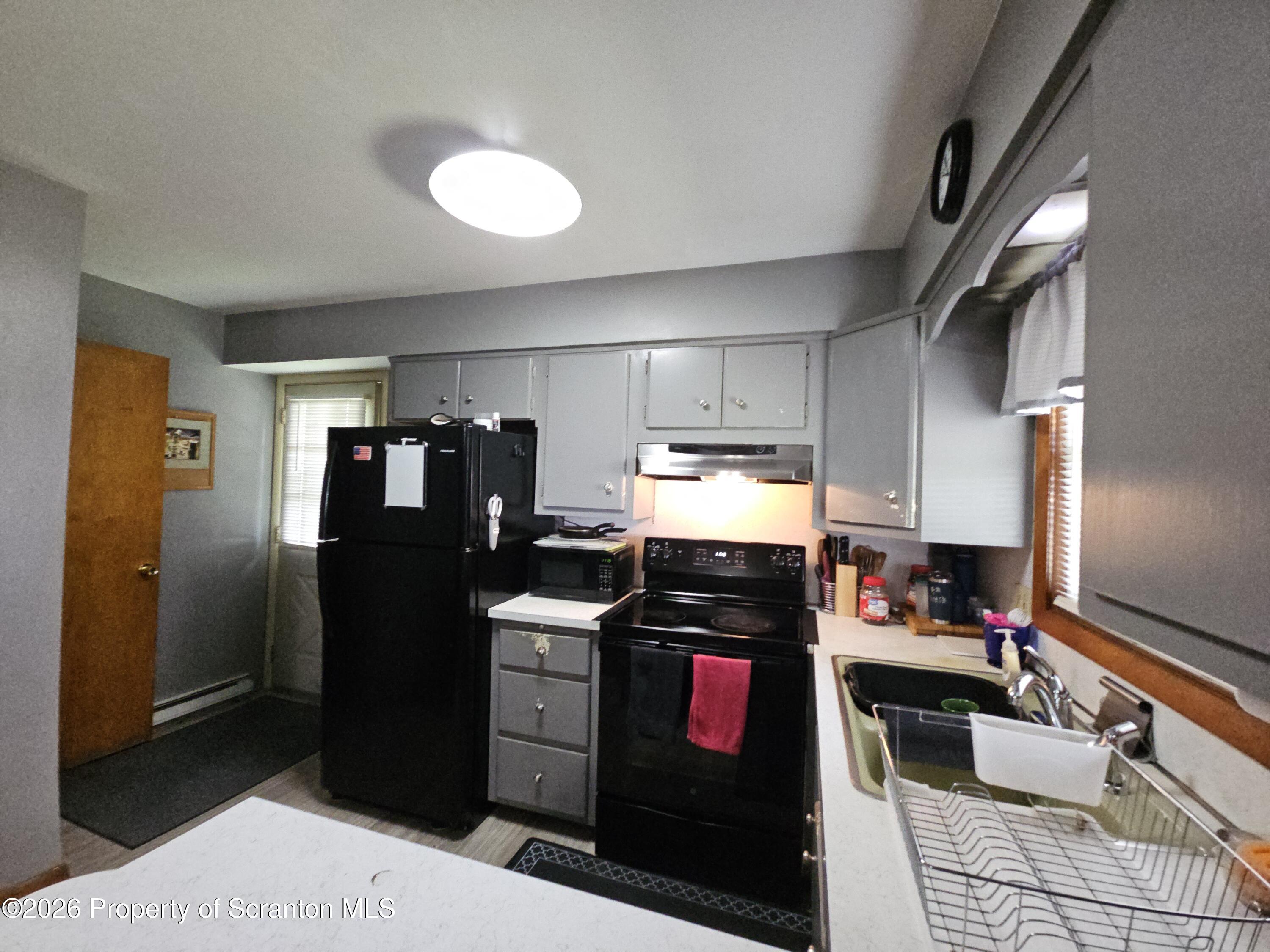 405 Baker Street Taylor, PA 18517 - Photo 10 of 36 a kitchen with stainless steel appliances kitchen island granite countertop a refrigerator stove and sink