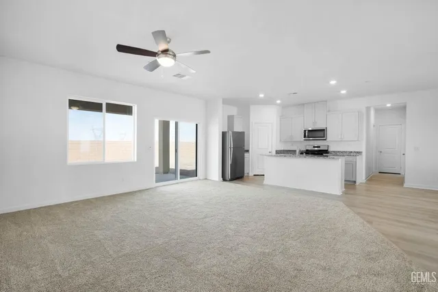 a view of an empty room with kitchen appliances and a window