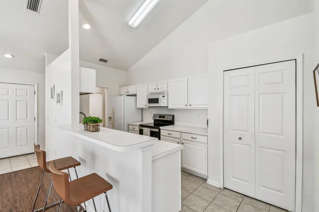 a kitchen with white cabinets and stainless steel appliances
