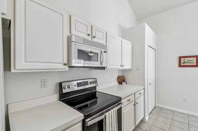 a kitchen with white cabinets and black appliances