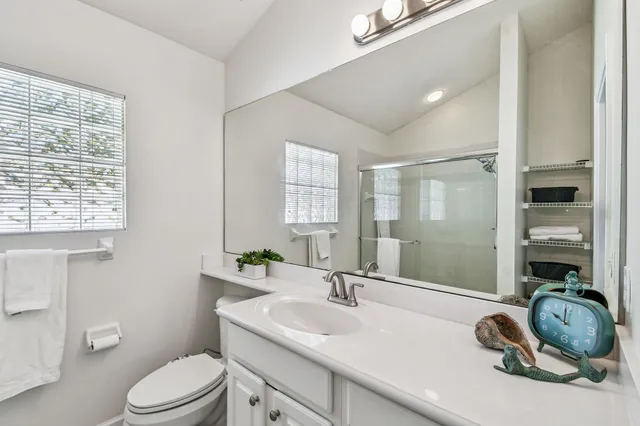 a bathroom with a granite countertop sink toilet a mirror and shower