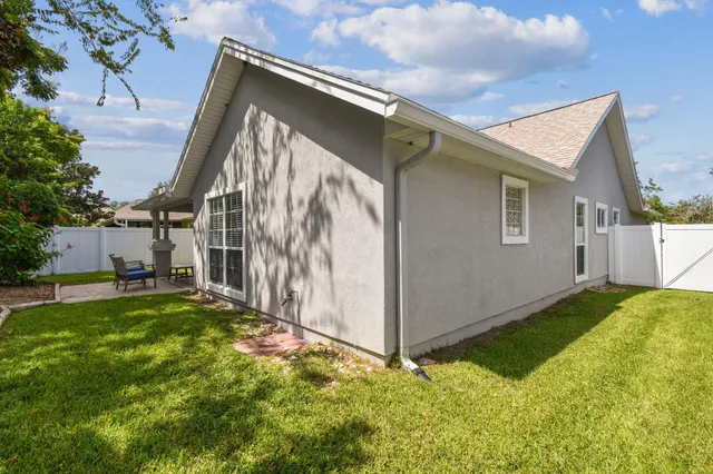 a backyard of a house with table and chairs