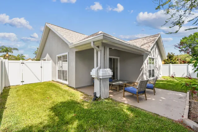 a view of a house with backyard and sitting area