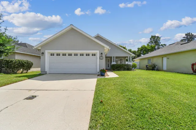 a front view of house with yard and garage