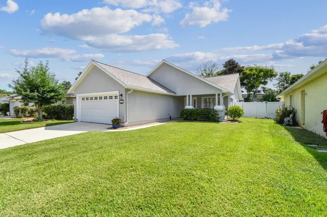 a view of a big house with a big yard and potted plants