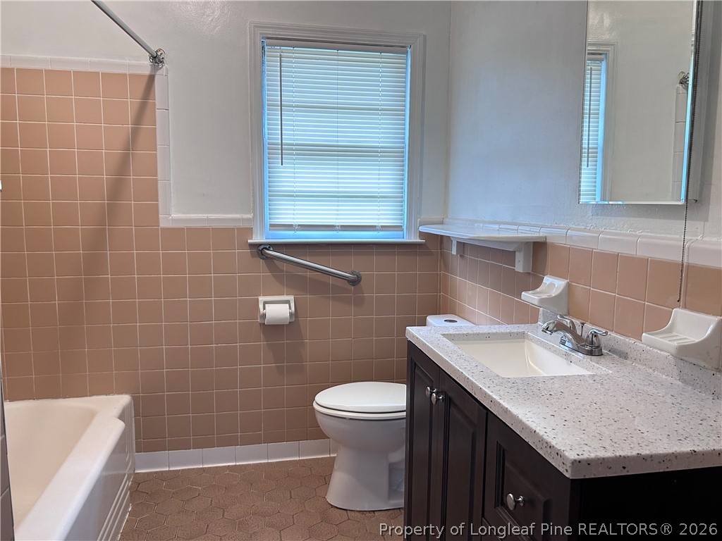 5200 Cypress Road Fayetteville, NC 28304 - Photo 6 of 9 a bathroom with a sink a toilet and a mirror