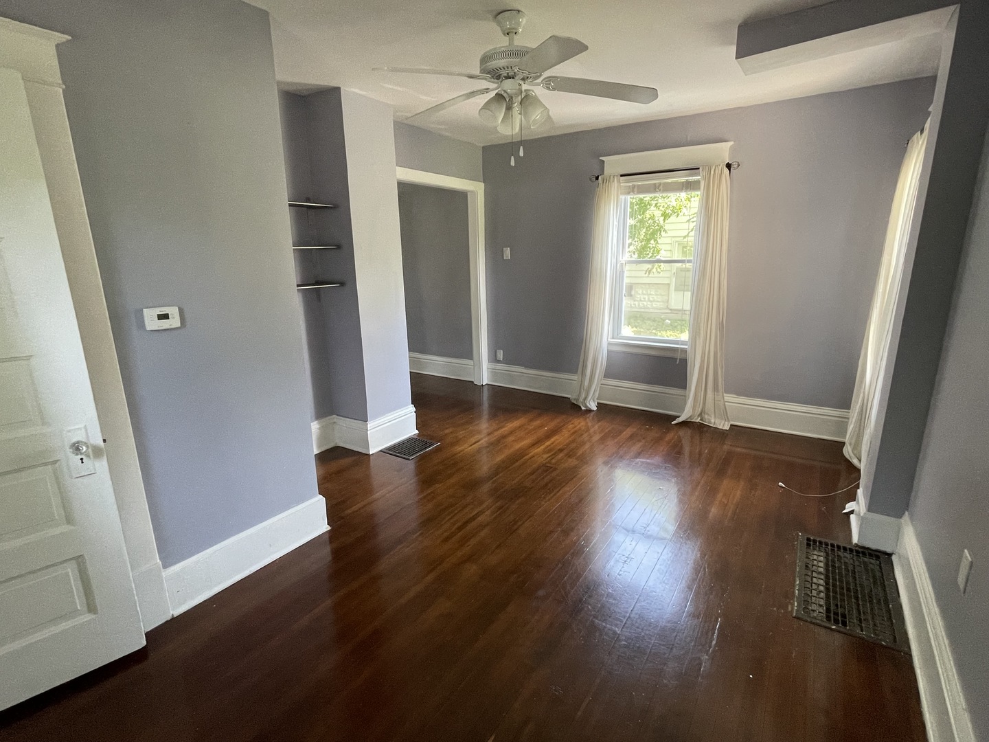 308 South Washington Street Wheaton, IL 60187 - Photo 12 of 27 an empty room with wooden floor and a ceiling fan