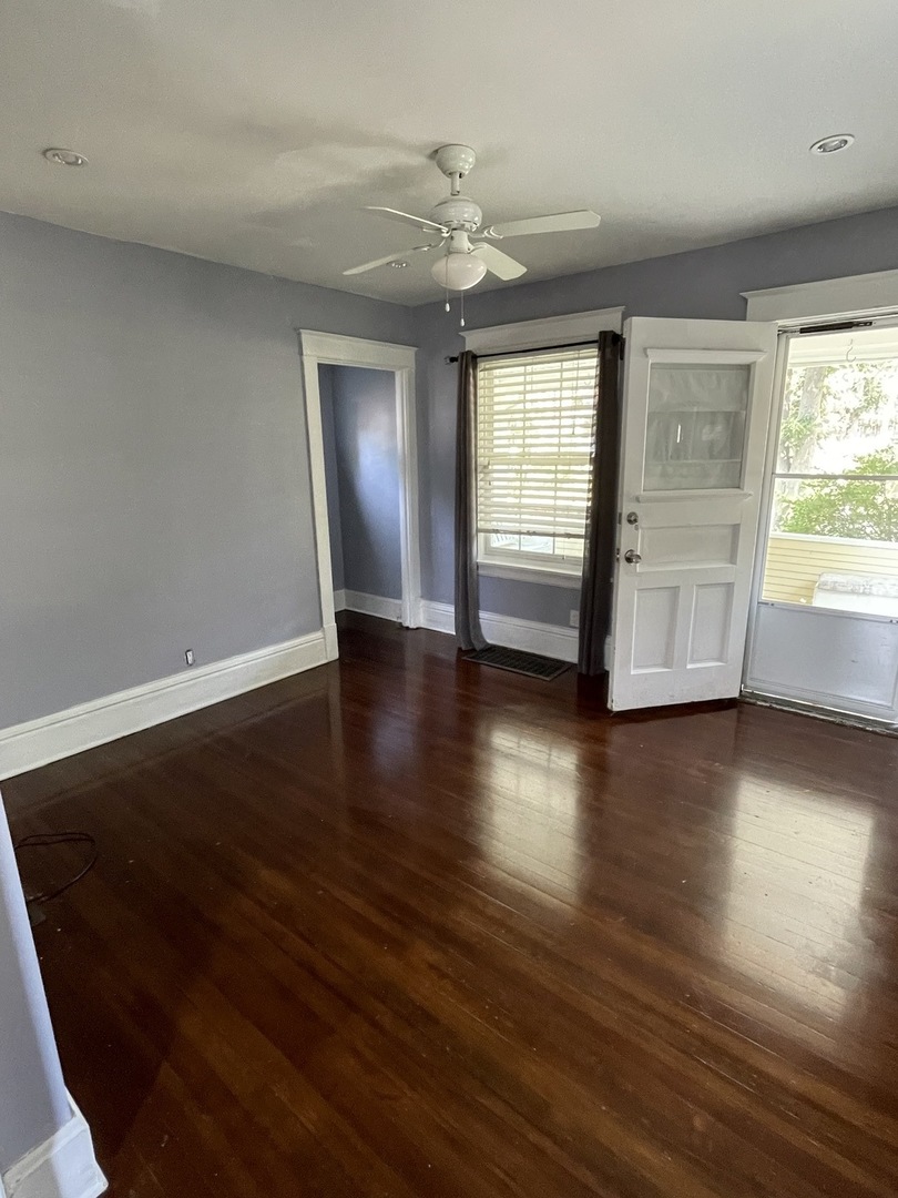 308 South Washington Street Wheaton, IL 60187 - Photo 6 of 27 an empty room with wooden floor chandelier and windows