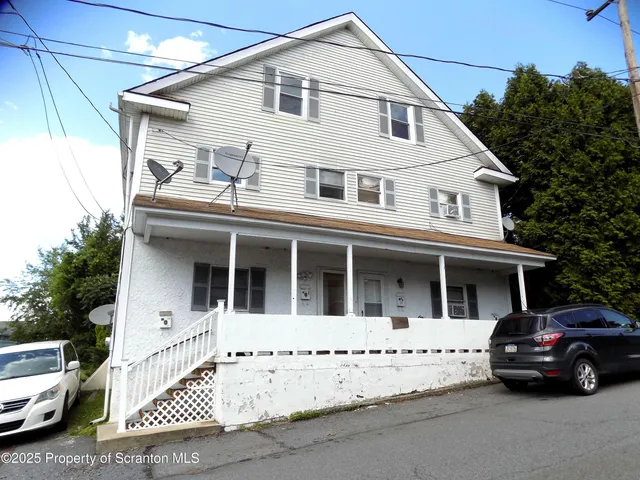 a view of a white house with a large space