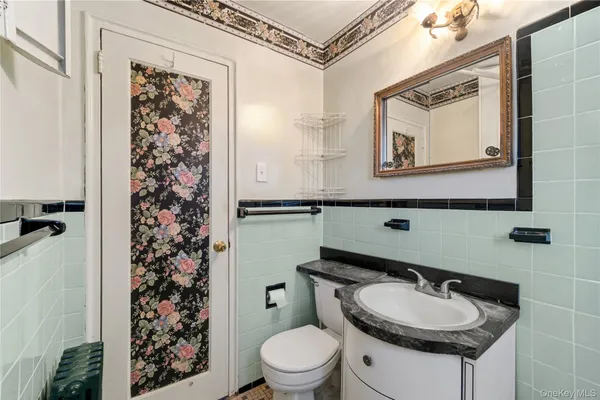 a bathroom with a toilet a sink and a mirror