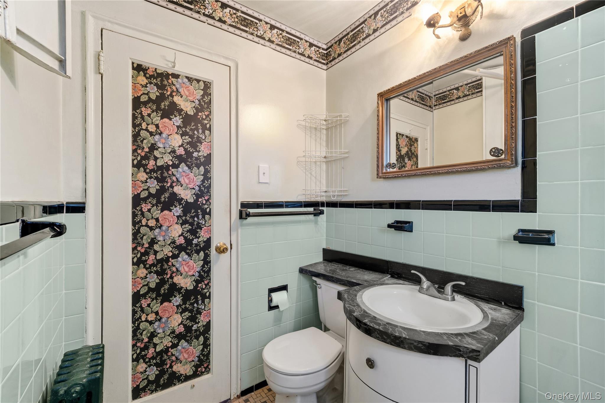 220-47 73rd Avenue, Unit UPPR Queens, NY 11364 - Photo 11 of 19 Half bath featuring tile walls, vanity, radiator, and a wainscoted wall