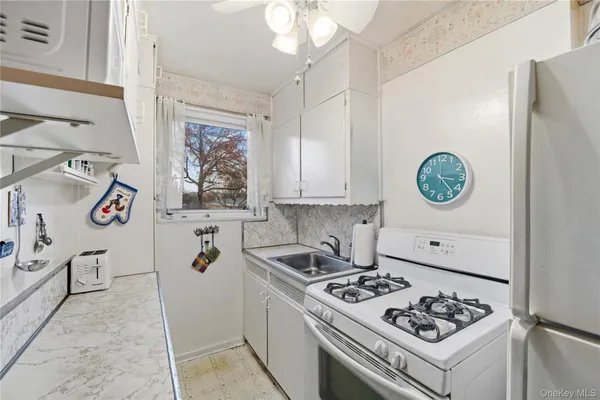 a kitchen with a stove and a refrigerator with white cabinets