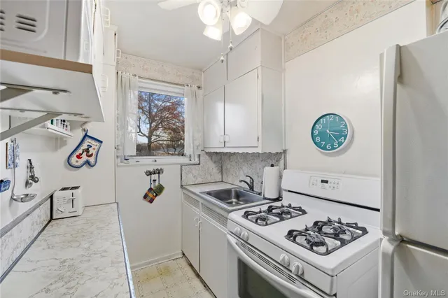 a kitchen with a stove and a refrigerator with white cabinets